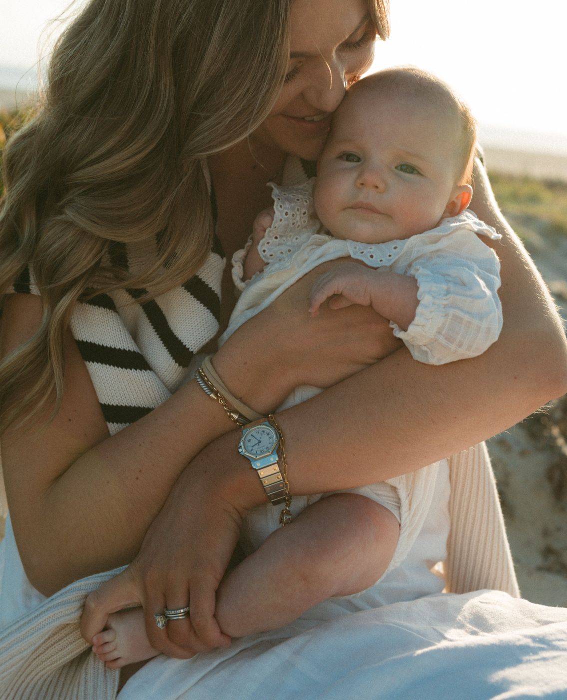 Alexa cuddling her baby at the beach